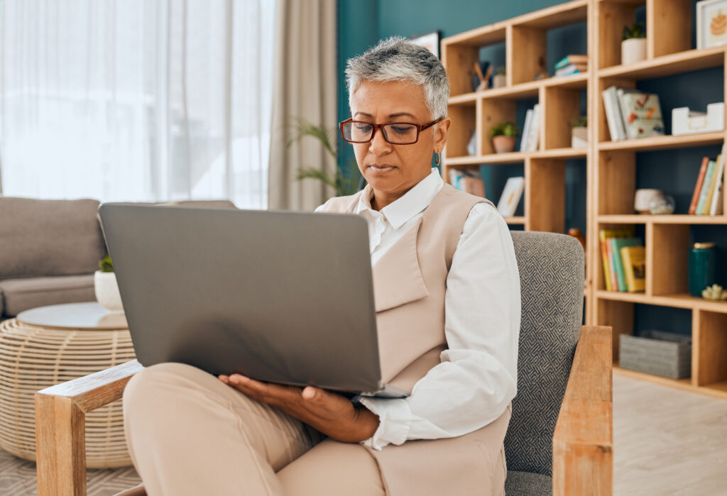 Mature psychologist, computer work and serious psychology doctor doing research in office. Therapist, reading and digital data planning of a mental health worker looking at online counseling notes.