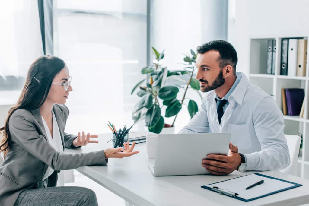 patient and doctor talking and looking at each other in clinic