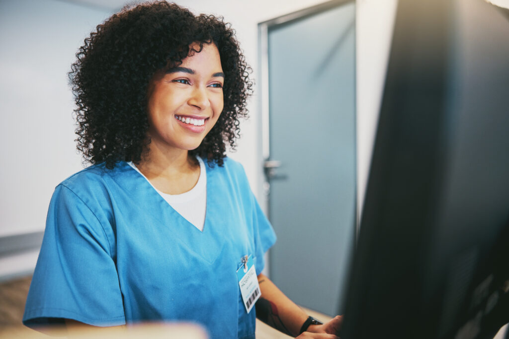 Computer, nurse and black woman typing research for healthcare reports or telehealth. Medical, health and happy female physician or doctor with desktop for writing or online consultation in hospital.