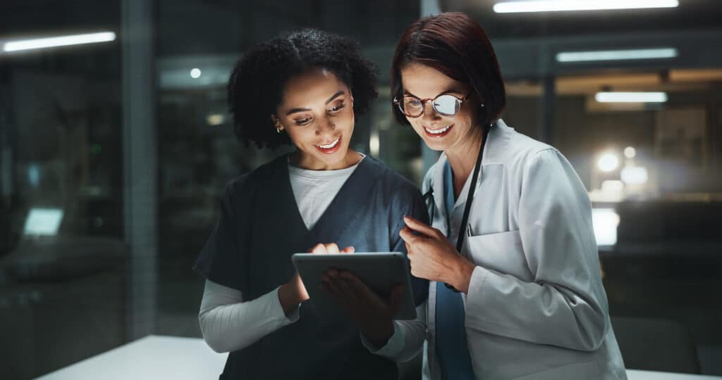 Night, doctor and happy surgeon on tablet for reading online for good news and late schedule in hospital. Medical results, overtime and women with technology, clinic website or telehealth digital app.