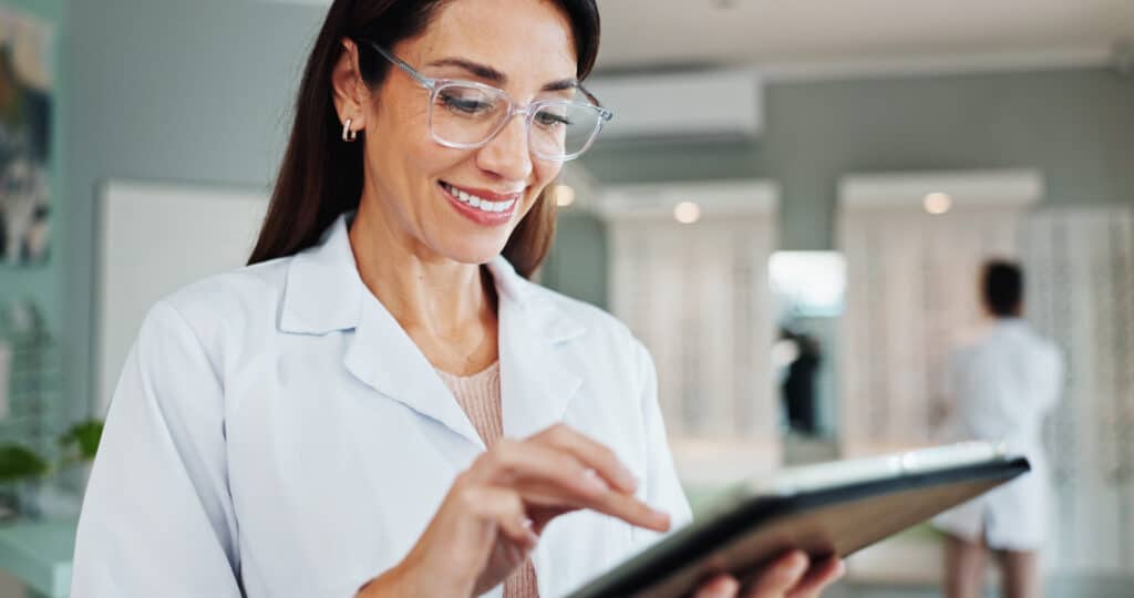 Smile, woman and optician on tablet for eye care, medical treatment or check eyesight test results. Digital technology, optometrist or store for ophthalmology research, healthy vision or prescription.