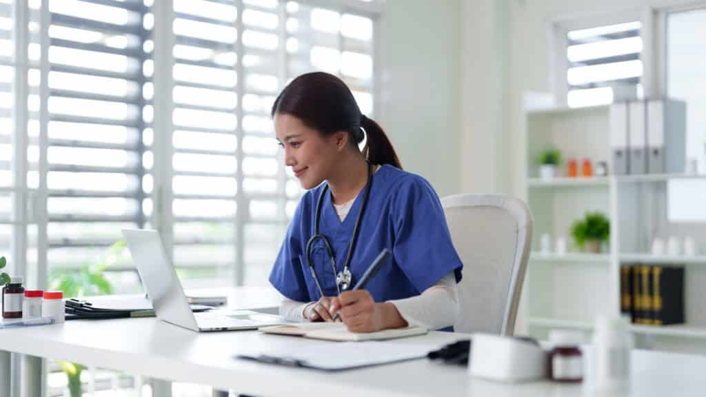 Asian adult female medical professional nurse doctor work laptop digital data healthcare records study online telemedicine consultation clinic office