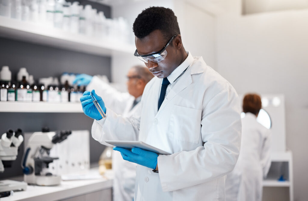 Science, research and black man in laboratory with tablet for medical analysis and digital innovation in medicine. Pharmaceutical analytics, web and scientist in South Africa checking results online