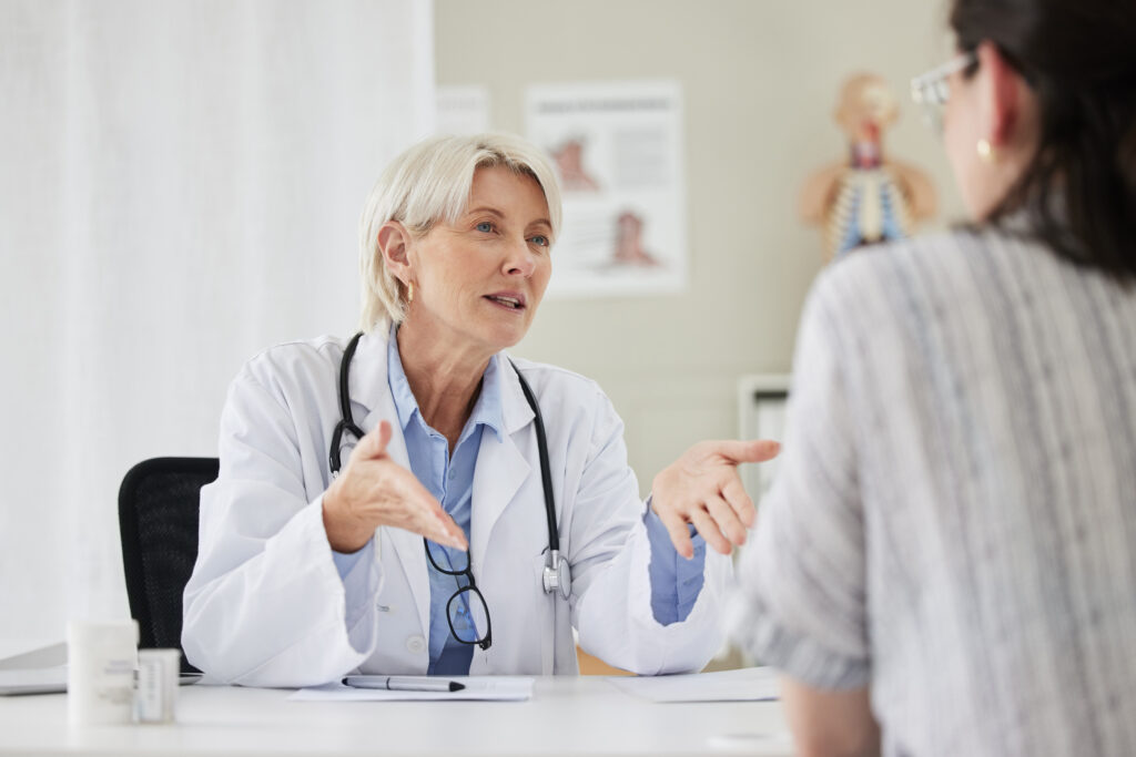 Senior, doctor and patient for consultation at the clinic about health condition and wellness. Medical, professional and women with communication at hospital in the office about medicine and surgery