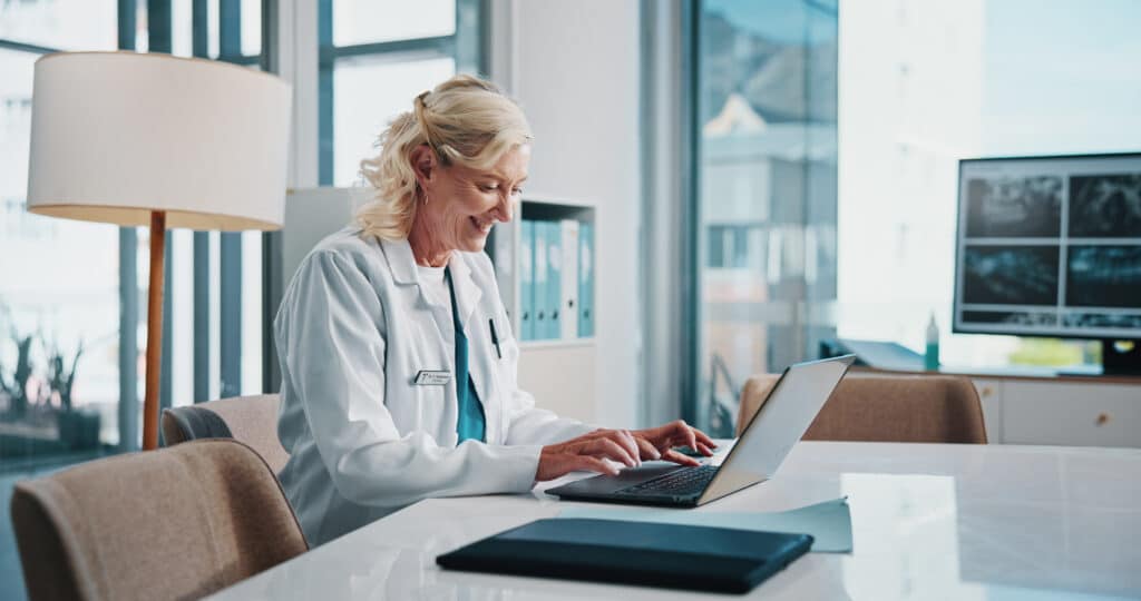 healthcare administrator reviewing provider credentialing application on computer