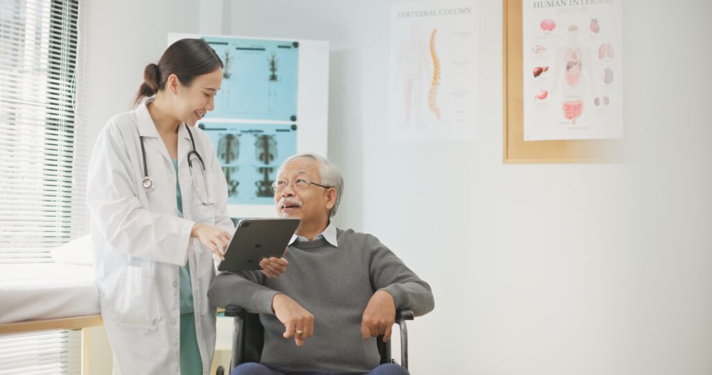 Asian female doctor using a digital tablet to explain health information to an elderly male patient, incorporating AI-assisted tools for better diagnosis, data analysis, and patient understanding.