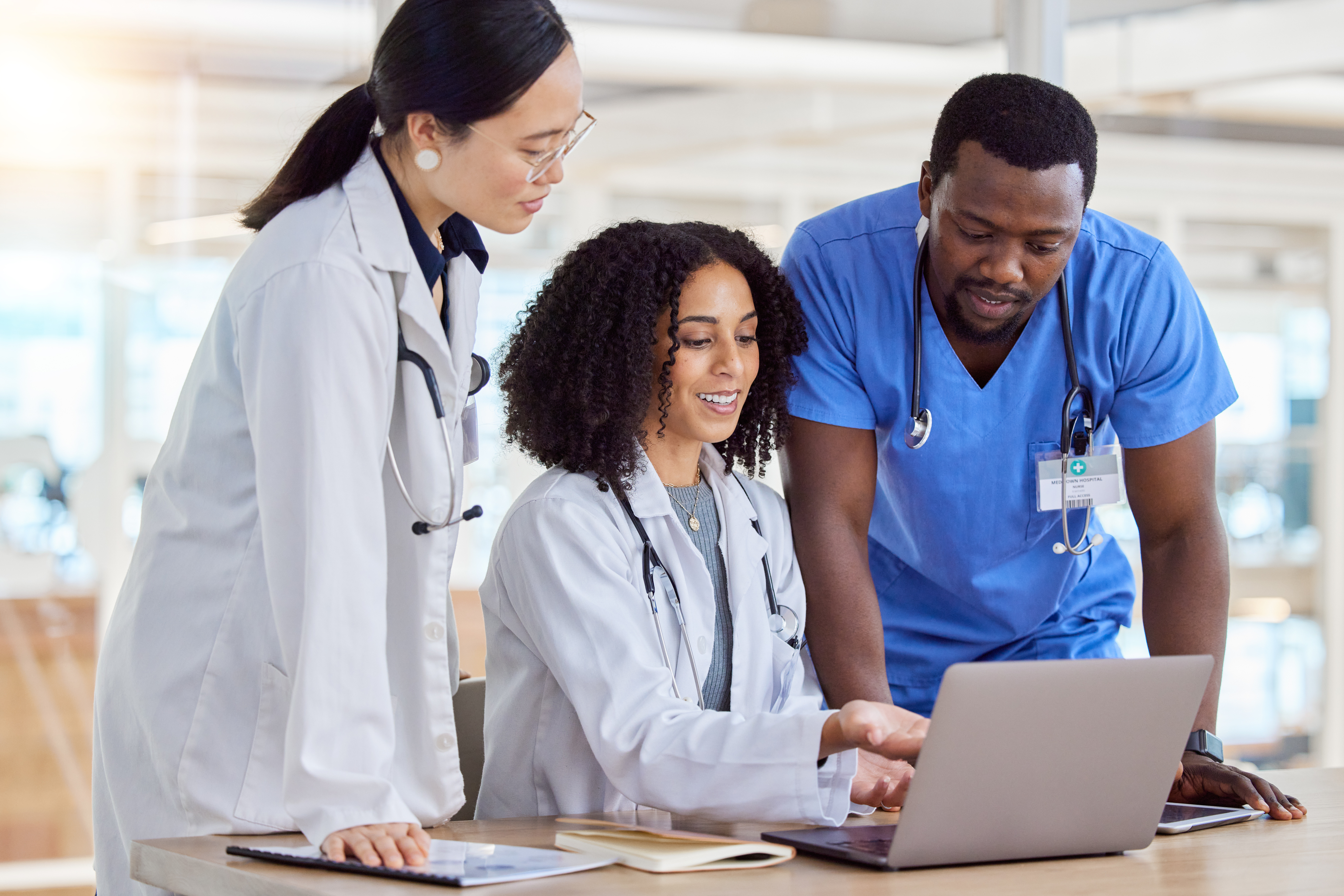 Laptop, group collaboration or doctors reading healthcare results, online clinic feedback or medicine report. Hospital diversity, communication or medical nurse, surgeon or staff teamwork on research.