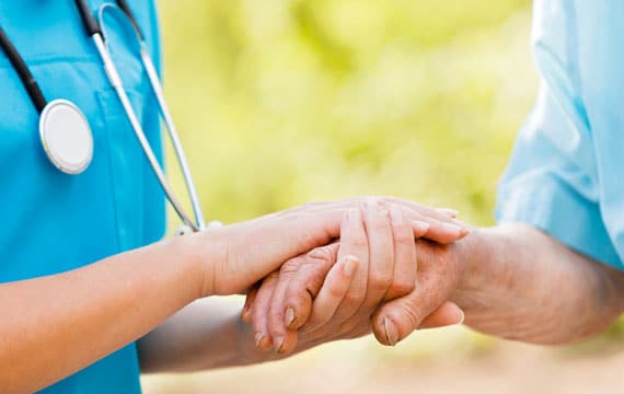 Nurse holding elder man hands for CCM services