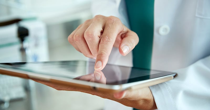 Medical staff reviewing patient data on a tablet