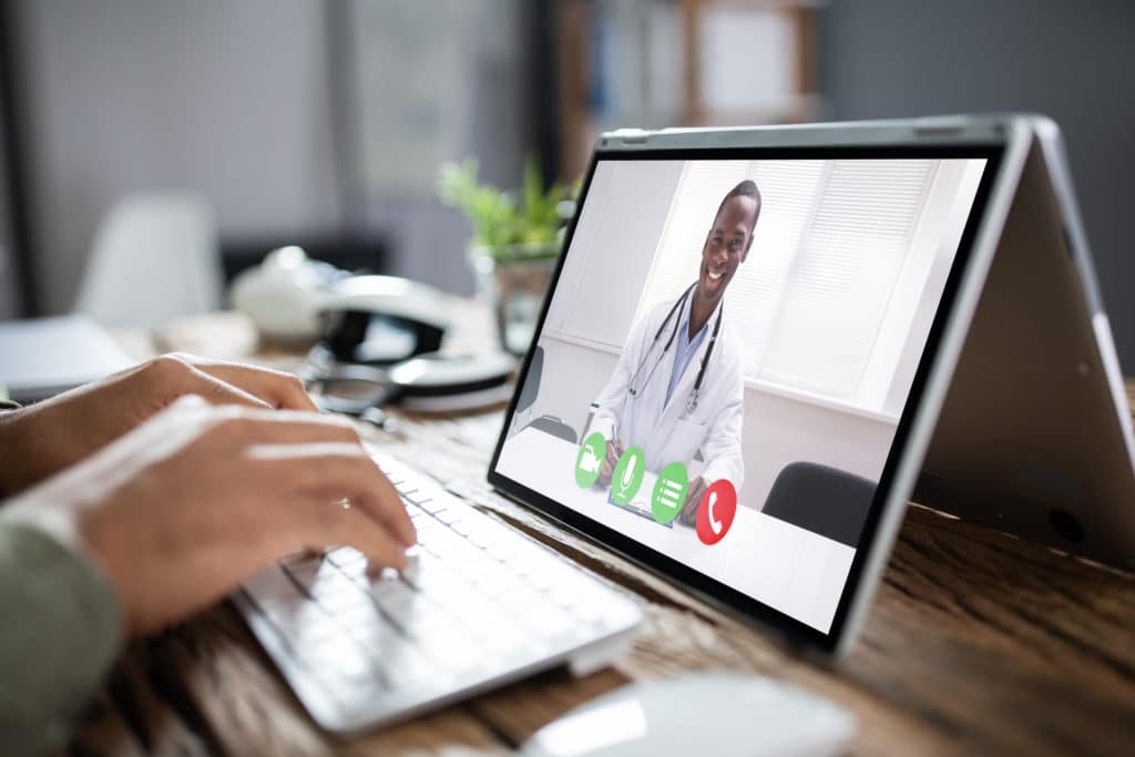 Male Doctor Video Chatting On Laptop