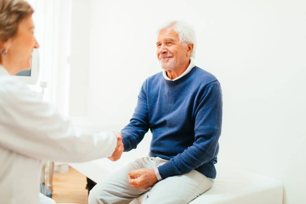 Satisfied patient handshakes with a doctor after medical examination