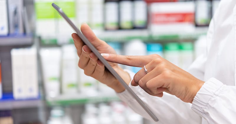 Doctor reviewing digital supply chain reports on a tablet