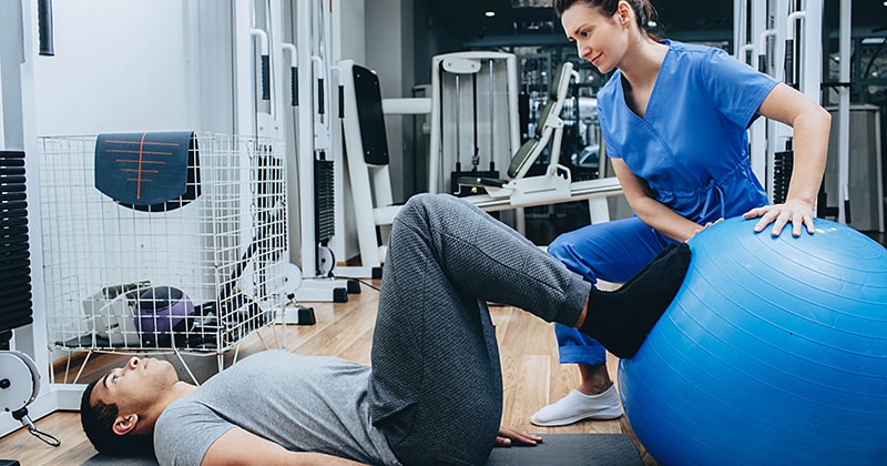 Physical therapist working with patient.
