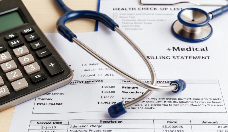 Stethoscope and calculator on top of a Medical Billing statement