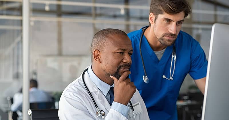 Medical staff discussing the differences between EHR and practice management software.
