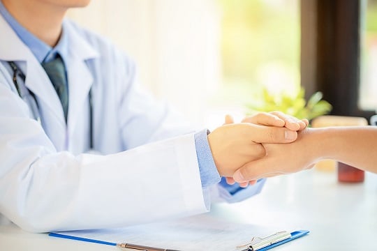 doctor hands holding patient's hand for encouragement.