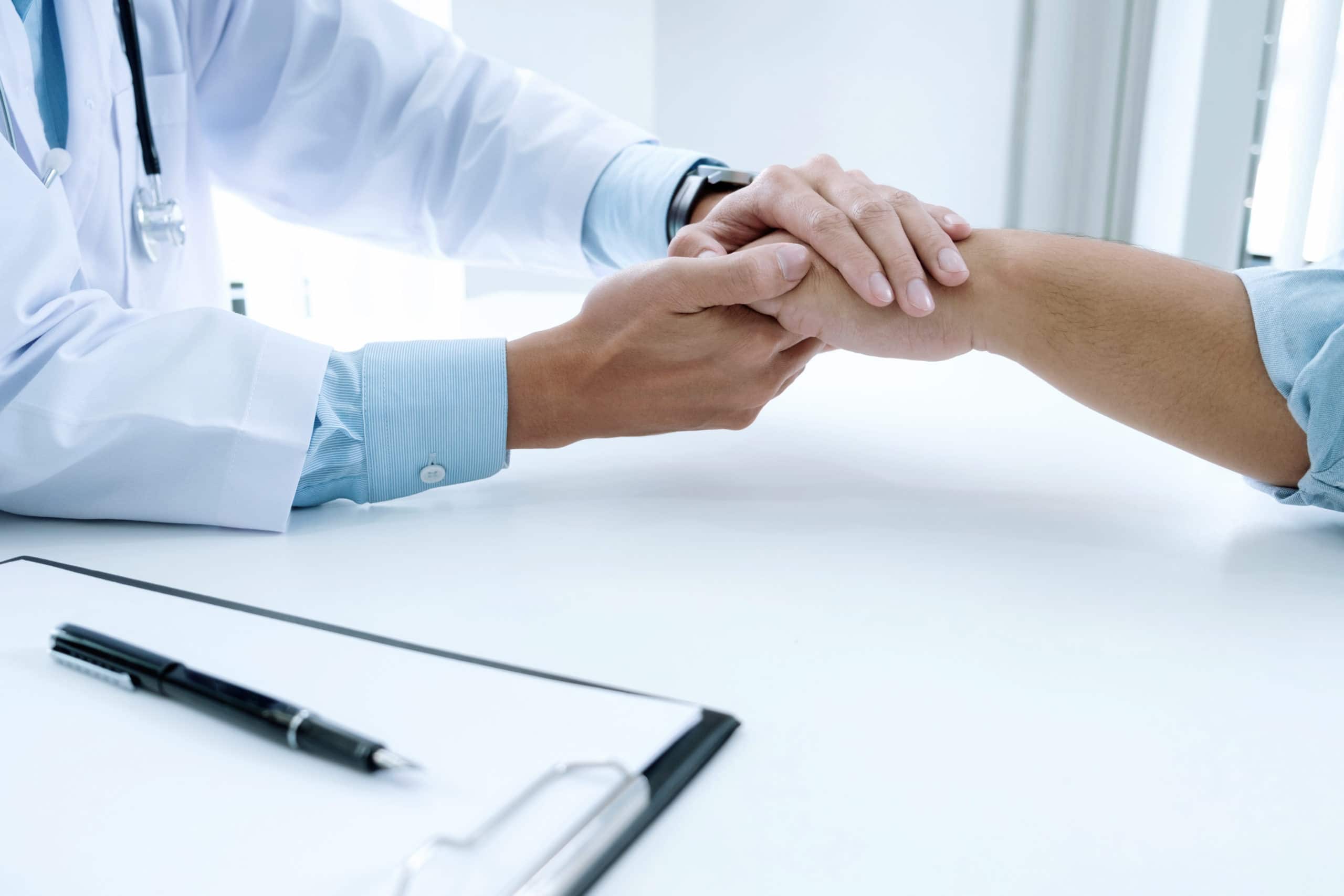 Doctor holding hand of patient