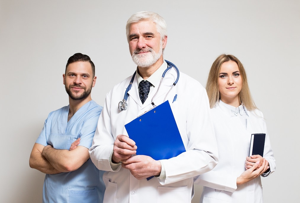 Three doctors smiling and looking into the camera