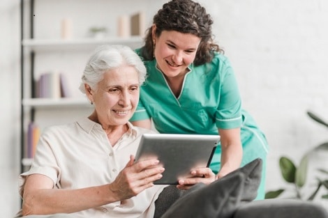 Nurse and elder patient looking at a table together.