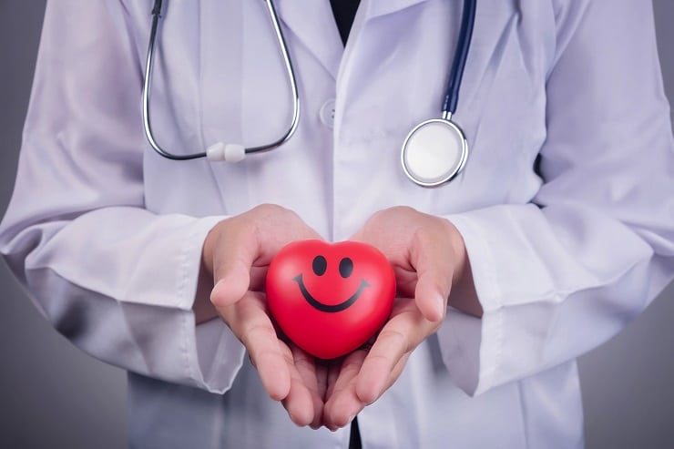 Red heart stress ball in a doctor's hand.