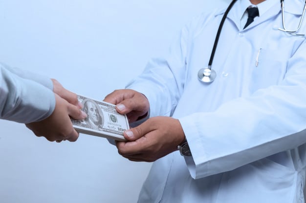 Patients hands money to doctor