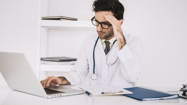 Doctor stressed in front of computer
