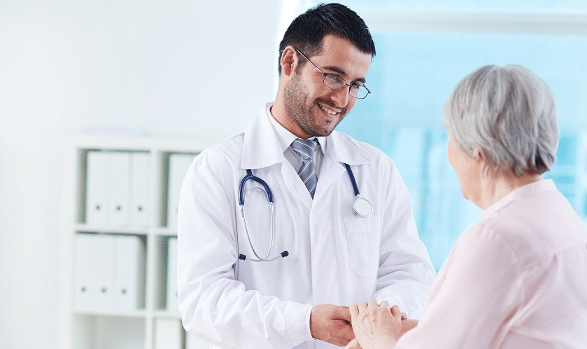 Doctor smiling at elder patient.